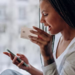 woman in white shirt holding smartphone