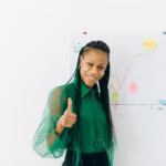 a woman in green long sleeves holding the thumbs up sign