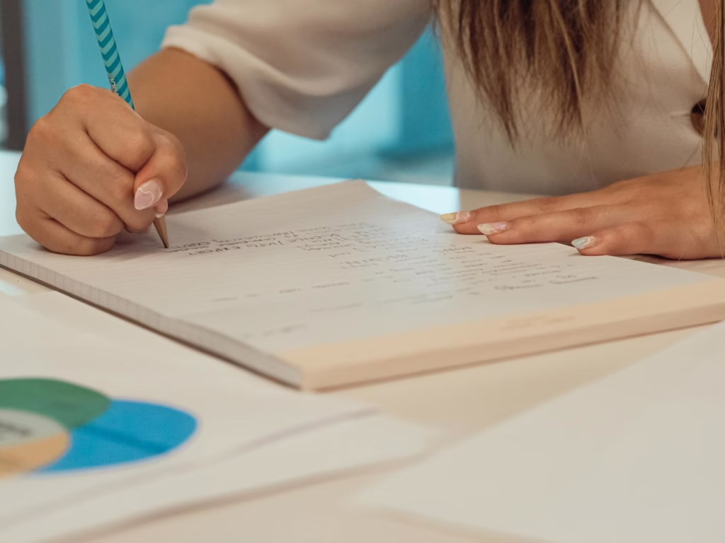 close up shot of a person writing on a paper