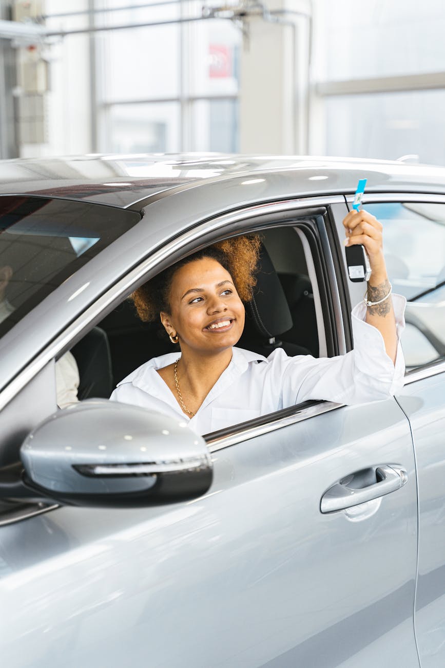 a woman inside a car showing her car key